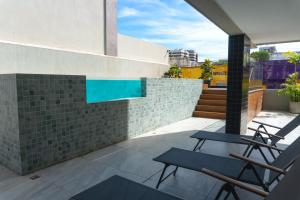 a patio with two chairs and a pool on a building at Top Unique Maceió in Maceió