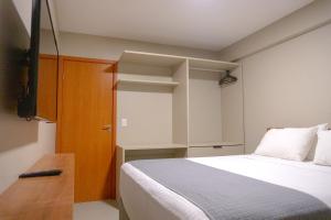 a small room with a bed and a tv at Top Unique Maceió in Maceió