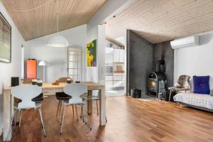 a dining room and living room with a table and chairs at fj1203-Jaegerspris-Birkagervej-14 in Jægerspris