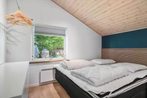 a large bed in a room with a window at fj1203-Jaegerspris-Birkagervej-14 in Jægerspris
