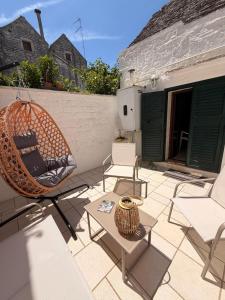 a patio with chairs and a swing and a table at La casetta di zia Giuseppina in Alberobello