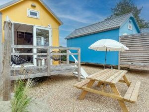 a bench and an umbrella next to a house at Bumble bee in Ellemeet
