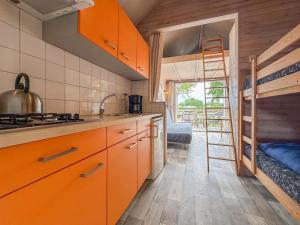a kitchen with orange cabinets and a bunk bed at Beach Blue in Ellemeet