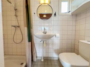 a bathroom with a sink and a toilet and a mirror at Beach Blue in Ellemeet +22 photos