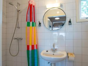 a bathroom with a rainbow shower curtain and a sink at Sandy Seven in Ellemeet +23 photos