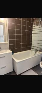 a bathroom with a tub and a toilet and a sink at Studio le balcon pied des pistes in Villard-de-Lans