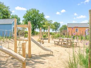 a playground with a slide and picnic tables at Sandy Seven in Ellemeet