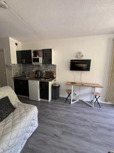 a room with a bed and a table and a kitchen at Studio le balcon pied des pistes in Villard-de-Lans
