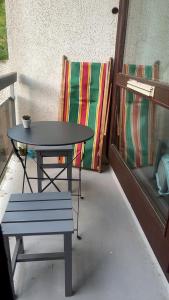 a table and a bench next to a table and a chair at Studio le balcon pied des pistes in Villard-de-Lans