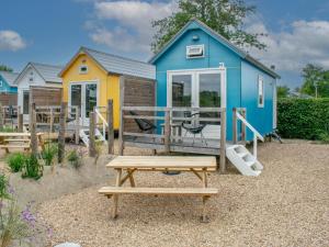a tiny house with a picnic table in front of it at Sea Blue in Ellemeet