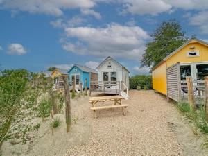 a row of beach huts sitting on top of a beach at Surfers Cabin in Ellemeet