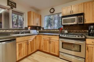 a kitchen with wooden cabinets and stainless steel appliances at Hibernation Hideaway- Inside Yosemite- Dog Friendly in South Wawona