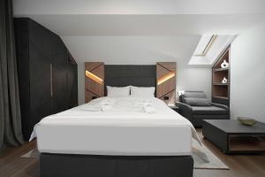 a bedroom with a large white bed and a chair at Panorama Mountain Tara in Kaludjerske Bare