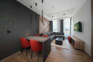 a living room with a table and red chairs at Panorama Mountain Tara in Kaludjerske Bare