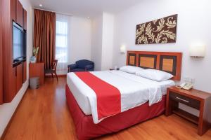 a hotel room with a bed and a television at Lampion Hotel Solo in Grogol