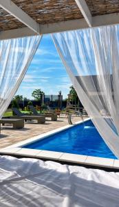 a swimming pool with a white curtain over it at Villa ZANS in Gradačac