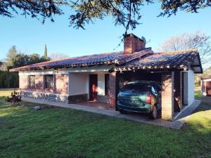 a small brick house with a car in the garage at Pinos del Virrey I in Valle Hermoso