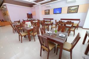 a dining room with wooden tables and chairs at Lampion Hotel Solo in Grogol