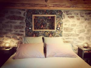 a bed in a room with a stone wall at Le Clos de Saussac in Yssingeaux +13 photos