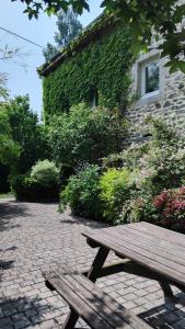 a wooden bench sitting in front of a building at Le Clos de Saussac in Yssingeaux