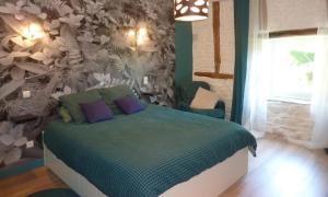 a bedroom with a bed with a floral wall at Le Clos de Saussac in Yssingeaux
