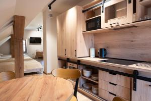 a kitchen with wooden cabinets and a table and a bed at Krępianka in Sandomierz +15 photos