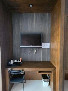 a room with a desk with a television on a wall at Guan Yu Boutique Hotel in Ban Thong Yi