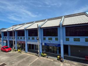 a building with a red car parked in a parking lot at Guan Yu Boutique Hotel in Ban Thong Yi