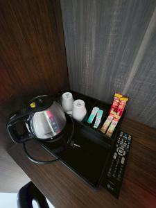 a desk with a phone and a remote control at Guan Yu Boutique Hotel in Ban Thong Yi