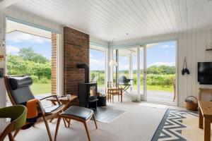 a living room with a fireplace and sliding glass doors at LF15083-Farso-Illeris-153 in Hole