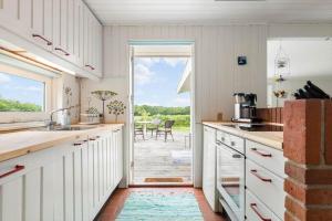 a kitchen with a door leading to a patio at LF15083-Farso-Illeris-153 in Hole +21 photos