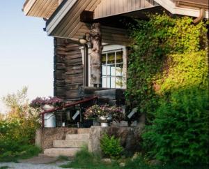 a house with stairs and a window and plants at Majatalo Puukarin Pysäkki in Nurmes