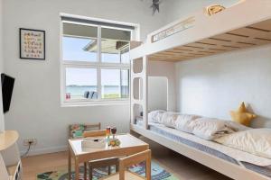 a bedroom with a bunk bed with a desk and a table at LF15163-Hojslev-Jelsevej-163 in Lundø