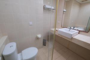 a bathroom with a toilet and a sink at Grand Orchid Hotel Solo in Solo +10 photos