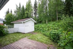 a small white shed sitting in a garden at Aurora Nest in Rovaniemi +6 photos