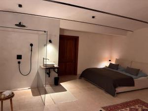 a bedroom with a bed and a shower in it at Leichtfried 1884 - Boutique Appartments in Möbersdorf