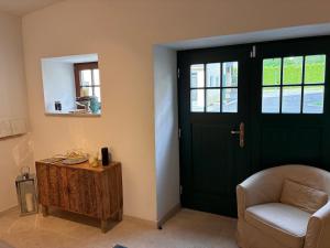 a green door in a room with a chair and a table at Leichtfried 1884 - Boutique Appartments in Möbersdorf