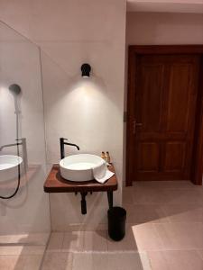 a bathroom with a sink on a wooden table with a door at Leichtfried 1884 - Boutique Appartments in Möbersdorf +3 photos