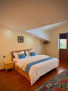 a bedroom with a large bed with blue pillows at 2149 Hotel in Khorog
