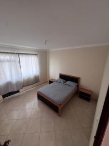 a bedroom with a bed and two windows in it at Maddox's Place in São Filipe +15 photos