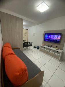 a living room with a bed and a flat screen tv at Monte Castelo Flat in Sairé