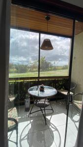 a patio with a table and chairs and a large window at Monte Castelo Flat in Sairé