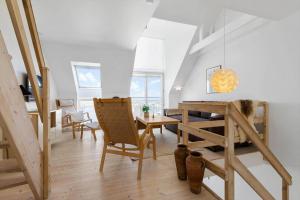 a living room with a table and chairs and a staircase at 8578-Glesborg-Agterspejlet-13 in Bønnerup Strand +18 photos