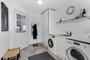 a white laundry room with a sink and a washing machine at 8578-Glesborg-Agterspejlet-13 in Bønnerup Strand