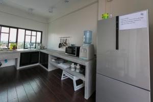 a kitchen with a counter and a refrigerator at Chedi View Hostel in Phetchaburi