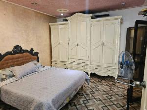 a bedroom with a bed and a fan at Café de Mazagran in Mostaganem