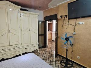 a bedroom with a tv on the wall and a bed at Café de Mazagran in Mostaganem
