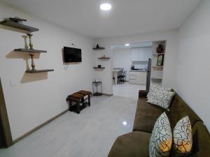 a living room with a couch and a tv at Casa Central in Cuenca