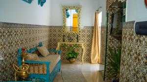a bathroom with a blue bed and a mirror at Maison Céline in Sousse