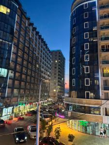 a city with tall buildings and a street with cars at Apartment Beach in Itʼkhvisi